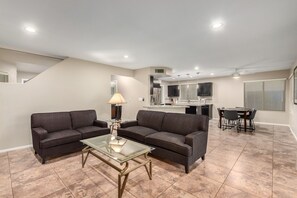 A modern living room with two sofas, a glass coffee table, and a dining area with a table and chairs. - Perfect Location in Phoenix!! (Phoenix)