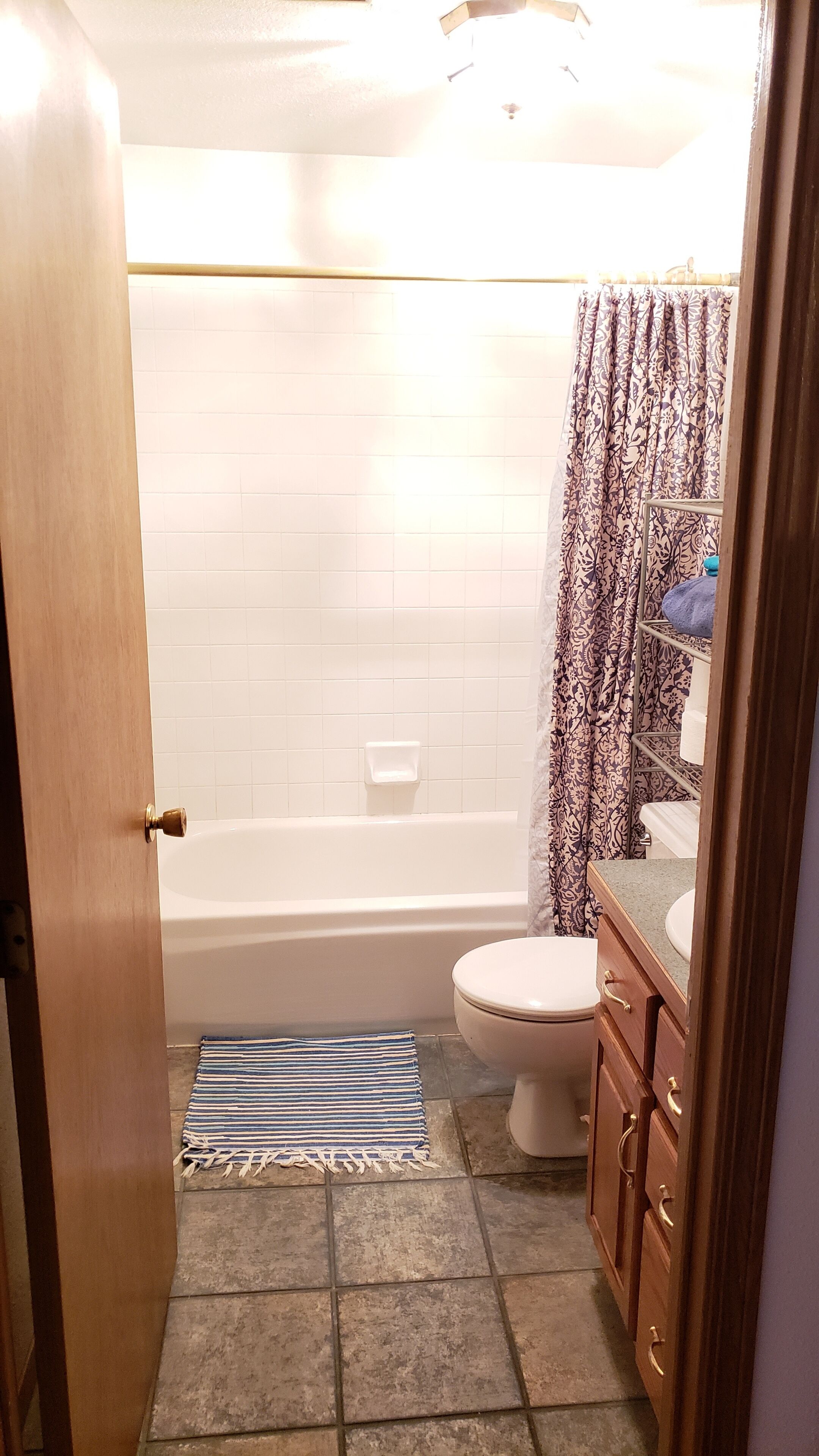 A bathroom with a bathtub, toilet, and a shower curtain.