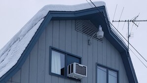 A two-story building with a garage, a sign indicating private property, and a snow-covered roof.