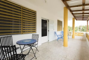 Relax in this serene outdoor space with a round table and comfortable seating for two.