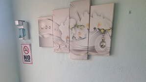 Eine Sitzecke mit einer Bank und einem Wandbild von weißen Blumen.