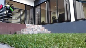 Un bâtiment moderne doté de grandes fenêtres, d’un escalier menant à un balcon et d’une personne portant un gilet de sécurité.