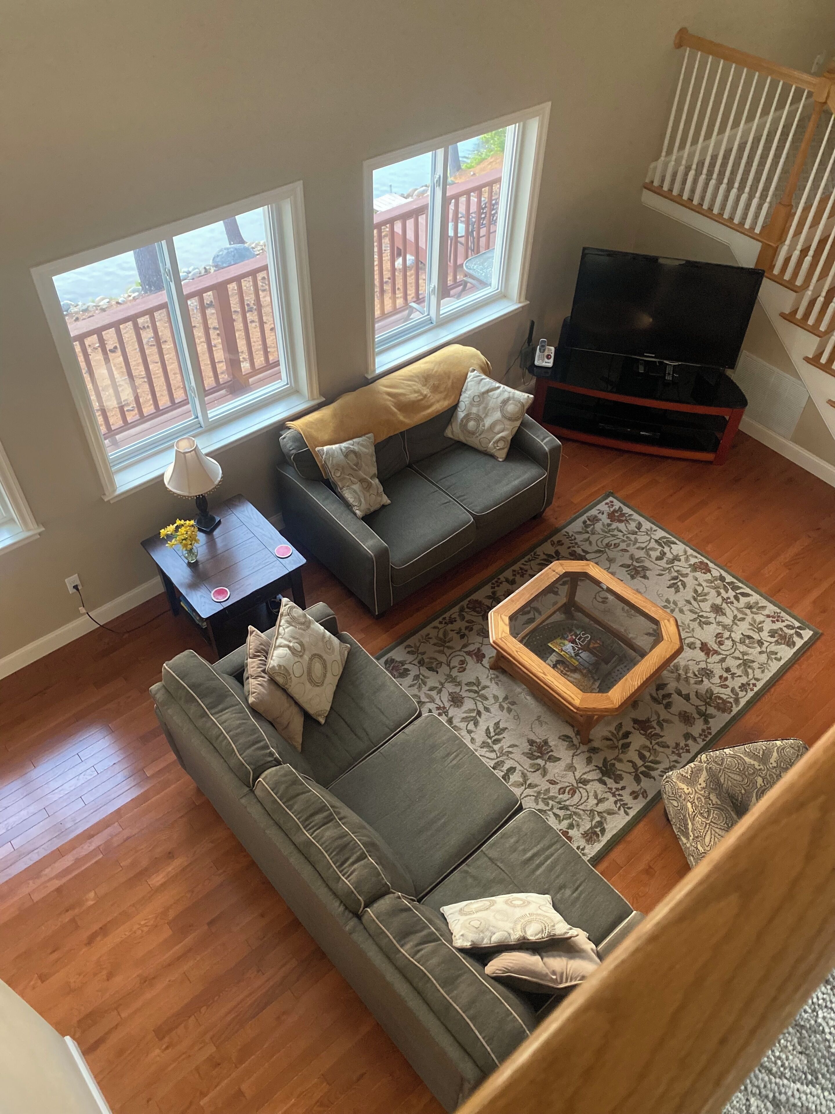 A living room with two grey sofas, a wooden coffee table, and a TV stand.
