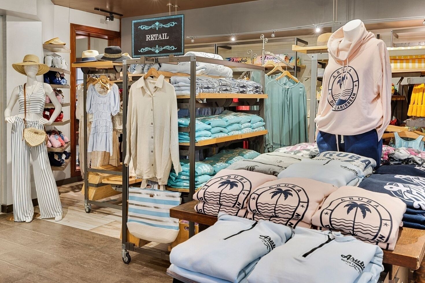 A retail clothing store with various apparel items on display, including a sign indicating the section.