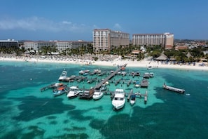 A coastal resort with a marina, beach, and hotel buildings. - Palm Beach Aruba | Couples Caribbean Getaway | Pool + Beach (Palm Beach)