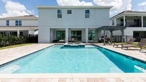Un bâtiment moderne à deux étages, avec une piscine située à l’avant.