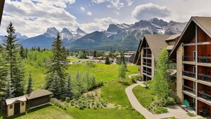 Eine Lodge mit Bergblick, ein gewundener Pfad und ein kleines Gebäude im Vordergrund.