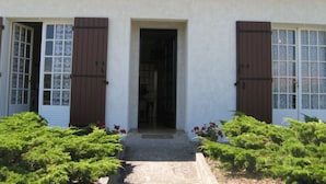 A two-story building with a white facade, brown shutters, and a tiled roof. - Vacation home on the dune, directly on the beach, simple but ideal for the vacations (Hourtin)