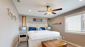A bedroom with a bed, bedside tables, a ceiling fan, and a window with blinds. - Golf Cart Included, First Floor, Near Marina, Pet Friendly (Port Aransas)