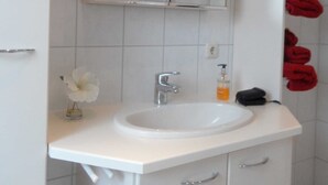 A bathroom with a white sink, mirror, and towel rack.
