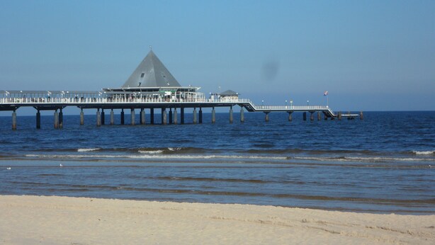 A pier extending into the water with a building at the end.