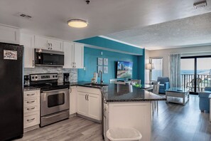 A modern kitchen with a built-in stove, microwave, and coffee maker. - Coastal Luxe | Palace Twenty-One Thirteen (Myrtle Beach)