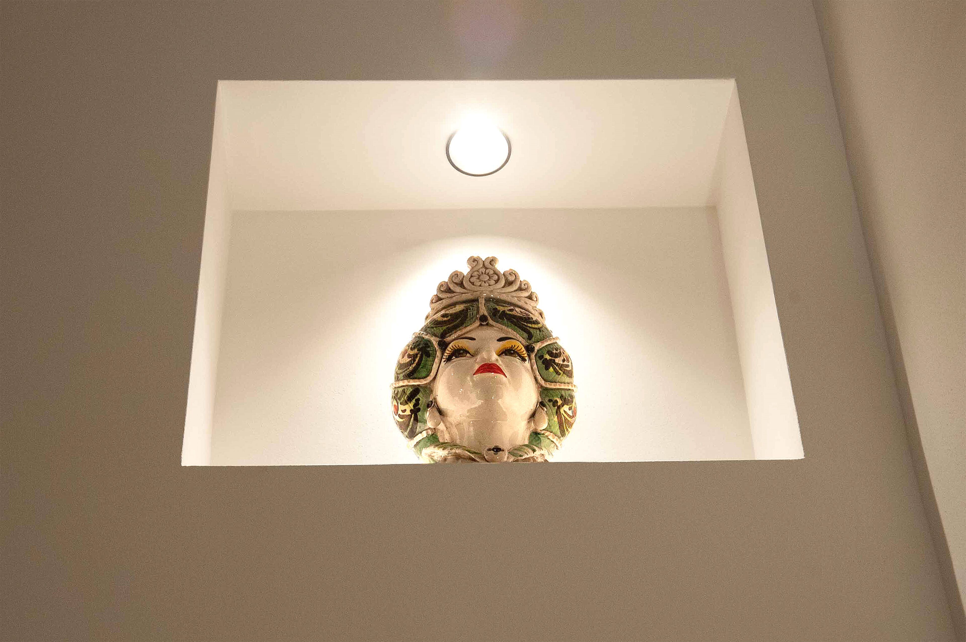 A ceiling with a recessed light fixture and a decorative element.