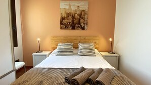 Ein Hotelzimmer mit einem großen Bett, zwei Nachttischen, einer Kopfteil und einem Stadtbild an der Wand.