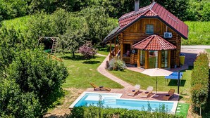 A log cabin with a swimming pool, surrounded by lush greenery. - Cozy home in Vinogradi Ludbreski with sauna (Vinogradi Ludbreski)