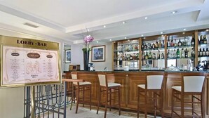 A lobby-bar area with a bar counter, multiple seating options, and a menu board. - Alimandi Vaticano (Rome)