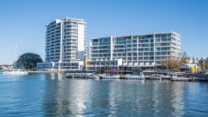 A waterfront hotel with multiple floors, a marina with boats, and a clear blue sky. - Beach Home: Epic Views: Private Enclosed Yard:Pets (Halls Head)