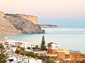 A coastal town with buildings near cliffs and the sea.