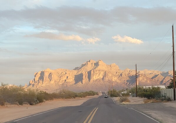 A road leading to a mountainous area with sparse vegetation.