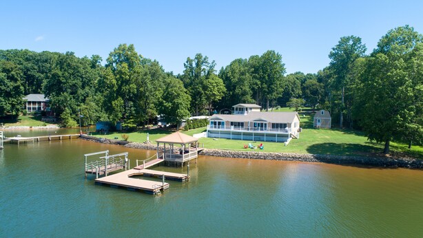 A lakeside property with a dock, a gazebo, and a large house with a deck. - Timeless Memories by SoCharm | Amazing Views & Guest Suite!| Dock & Firepit (Mooresville)