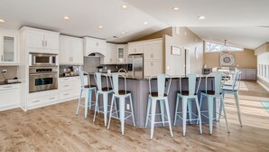 A modern kitchen with white cabinetry, stainless steel appliances, and a central island with bar stools. - Timeless Memories by SoCharm | Amazing Views & Guest Suite!| Dock & Firepit (Mooresville)