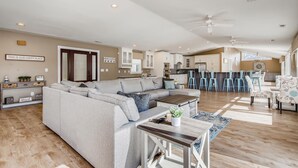 A spacious living room with a sectional sofa, a coffee table, and a dining area with blue chairs. - Timeless Memories by SoCharm | Amazing Views & Guest Suite!| Dock & Firepit (Mooresville)
