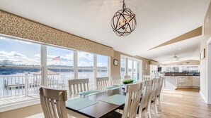 A spacious dining area with a view of a lake, a modern kitchen, and a balcony with a railing. - Timeless Memories by SoCharm | Amazing Views & Guest Suite!| Dock & Firepit (Mooresville)