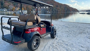 A golf cart parked on a sandy shore with a lake and hills in the background. - ★Views★Golf Cart Included★Behind Resort Gate★Member Areas Included (Lake Lure)