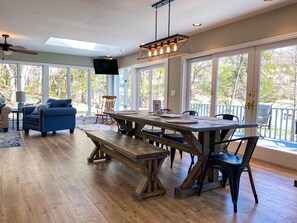 Un vaste espace de vie comprenant une table à manger en bois, des bancs et un canapé bleu.
