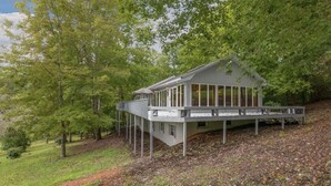 A modern house with a large deck and a covered porch, surrounded by trees. - ★Views★Golf Cart Included★Behind Resort Gate★Member Areas Included (Lake Lure)