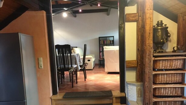 Een gezellig interieur met een houten bank, een open haard en een boekenplank.