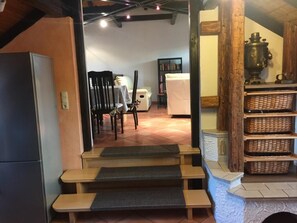 A cozy interior with a wooden bench, a fireplace, and a bookshelf.