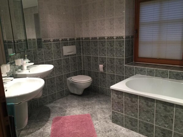A bathroom with a toilet, sink, and bathtub.