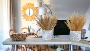 Une table à manger agrémentée de trois vases décoratifs contenant des plantes séchées.