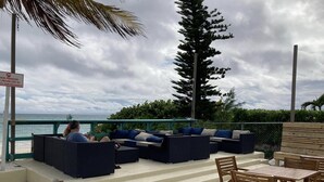 An outdoor seating area with sofas and tables, overlooking the ocean. - Stunning Oceanfront Condo at Coral Beach unit 1107 (Freeport)