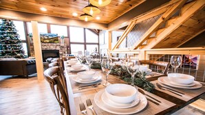 A long dining table set with white plates, bowls, and cutlery, flanked by wooden chairs. - Gorgeous Luxury Cabin! 360 Views, Fire Pit, Theater Room - Prime Location!  (Gatlinburg)