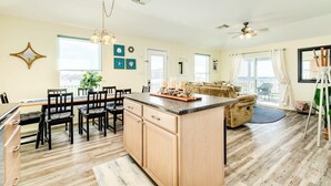 Un'ampia cucina con isola centrale, mobili in legno e zona pranzo con sedie e tavolo.