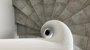 Eine Wendeltreppe mit grauen Fliesen und einem weißen, flauschigen Gegenstand unten.