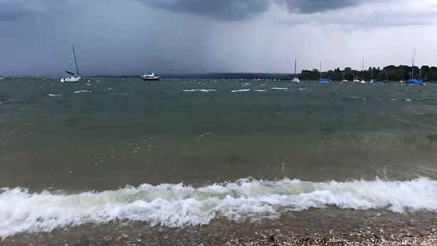 Ein Strand mit Booten und einem bewölkten Himmel.