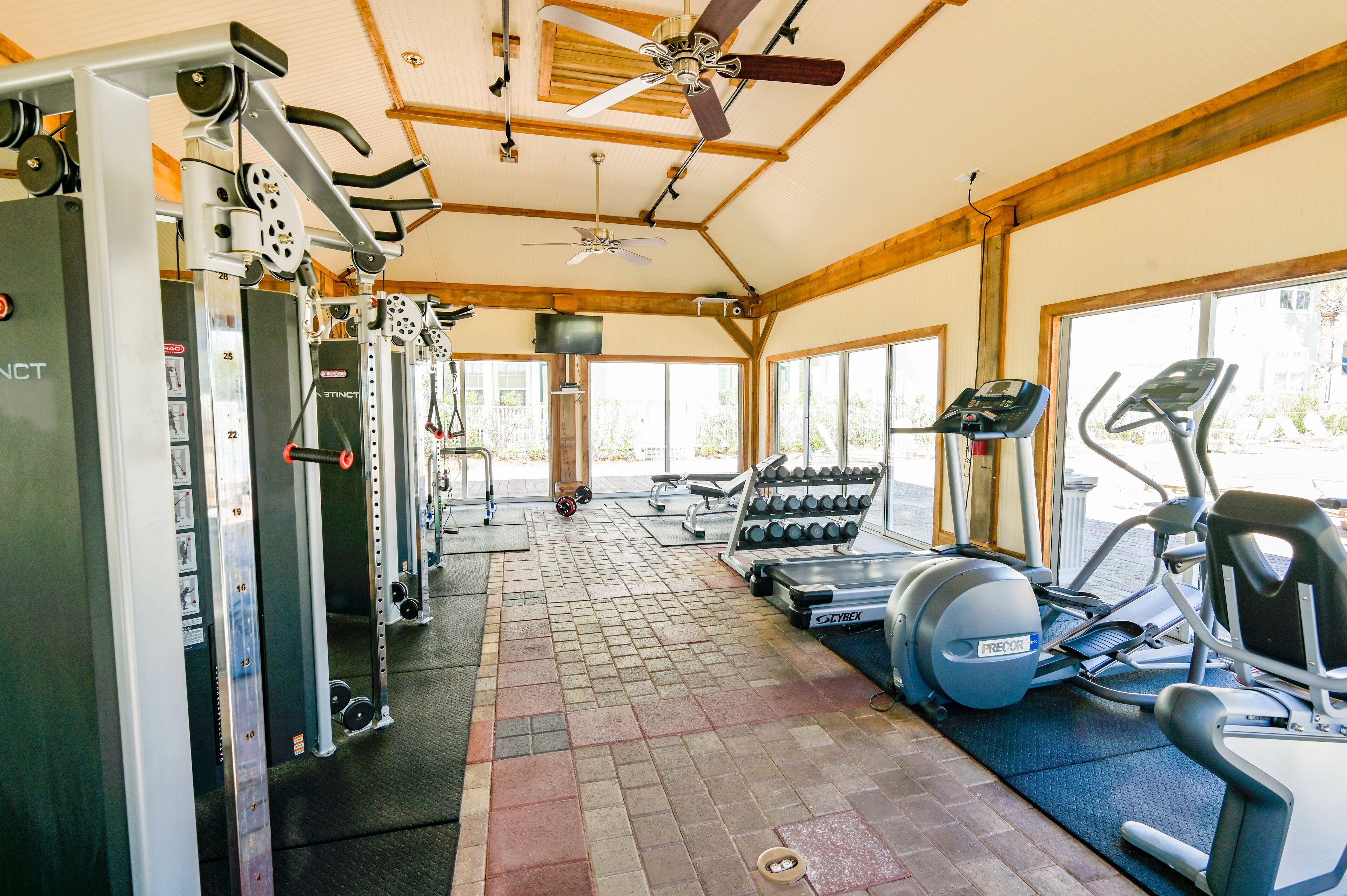A gym with weight machines, treadmills, and dumbbells.