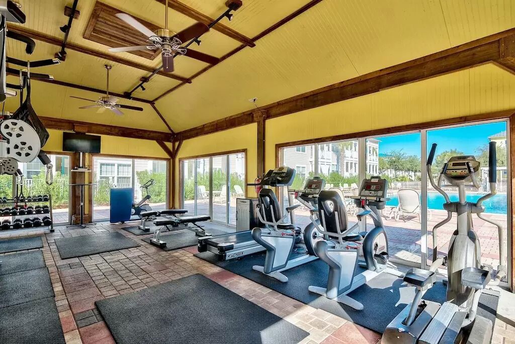 A gym with treadmills, weight machines, and dumbbells.