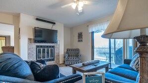 A living room with a fireplace, a television, and a sign that reads "welcome friends & family". - Unit B7 spacious 4bed/3bath condo perfect lakefront spot for family and friends (Osage Beach)