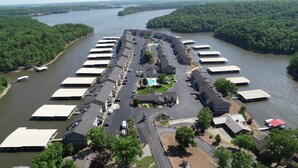 An aerial view of a marina with multiple docked boats, a swimming pool, and a parking area. - Unit B7 spacious 4bed/3bath condo perfect lakefront spot for family and friends (Osage Beach)