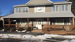 A two-story building with a porch, a sign indicating 90 parking spaces, and a satellite dish on the roof. - Catskills Adventures (Roscoe)