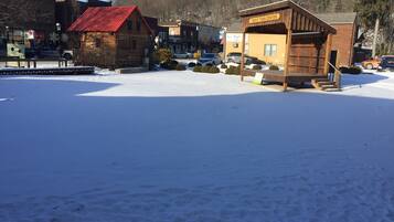 Centro de uma cidade coberta de neve, com edifícios de madeira, incluindo uma placa para Trout Town Center.