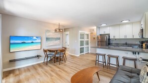 A modern kitchen with white cabinets, a stainless steel refrigerator, and a built-in oven.