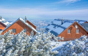 A wooden cabin with a sloped roof, surrounded by snow-covered trees, and a view of a distant landscape. - Beautiful home in Ebensee with WiFi (Ebensee)
