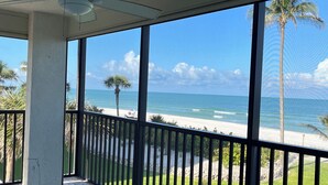 A balcony with a view of the beach and ocean. - Beachfront Vanderbilt Beach Condo in Naples, FL (Naples)