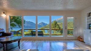 A room with a large sliding glass door leading to a balcony with a mountain view.