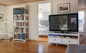 Relax in style with a flat-screen TV, bookshelf, and comfortable seating area.